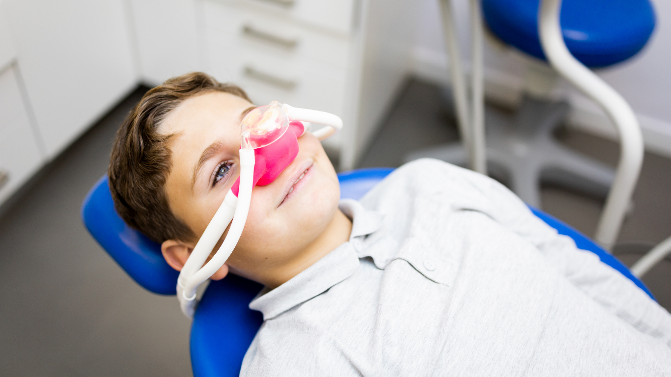 Child patient smiling and relaxed during dental treatment with nitrous oxide sedation in a dental office